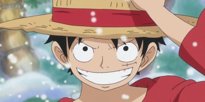 Luffy de One Piece sonriendo y sosteniendo su sombrero de paja.