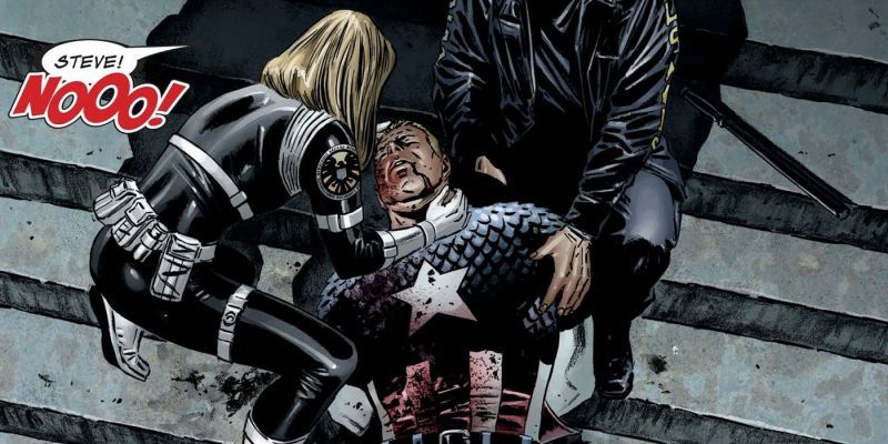 Steve Rogers in seinem Captain-America-Kostüm liegt stark blutend und ohnmächtig auf den Stufen eines Gerichtsgebäudes. Sharon Carter und ein weiterer SHIELD-Agent stehen über ihm.