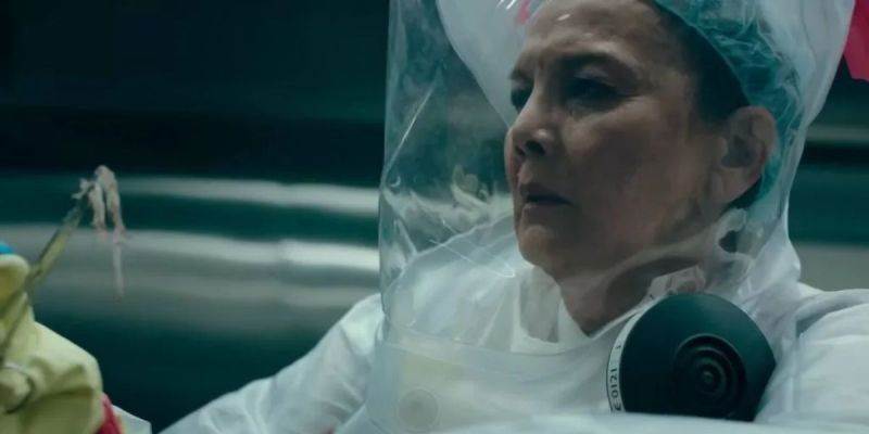 Ratna Pertiwi en un traje de materiales peligrosos sostiene zarcillos con pinzas en el episodio 2 de HBO